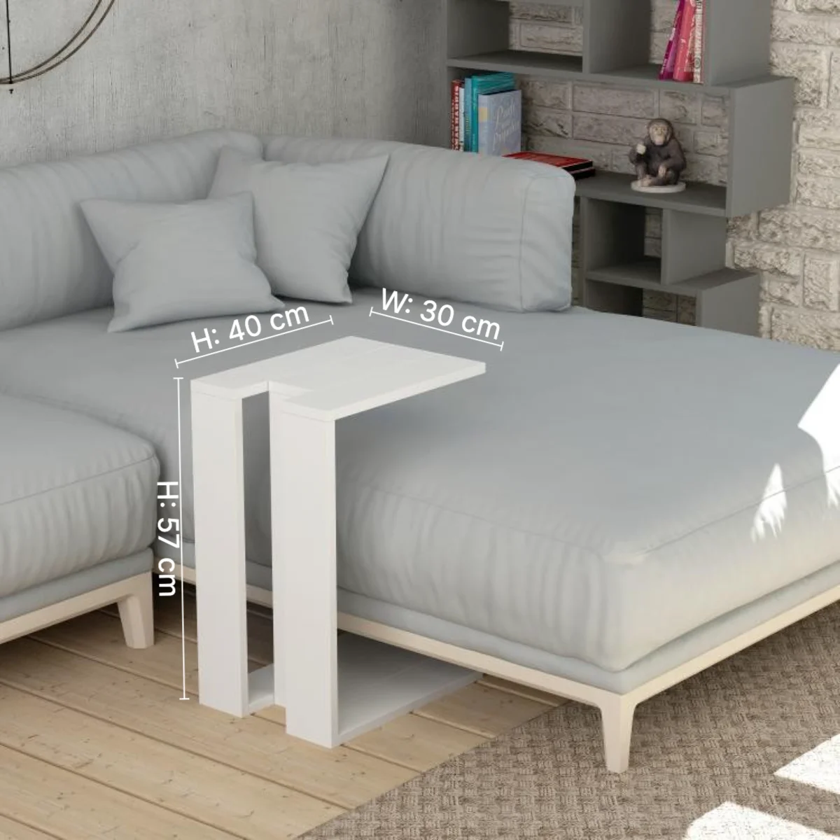 In-context furniture dimension image: white C-shaped side table beside a grey sofa with height 57 cm and top 40 by 30 cm marked inside the lifestyle scene